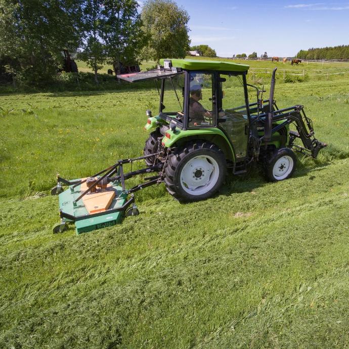 Tractor mounted mower mowing the grassland with a tractor mower